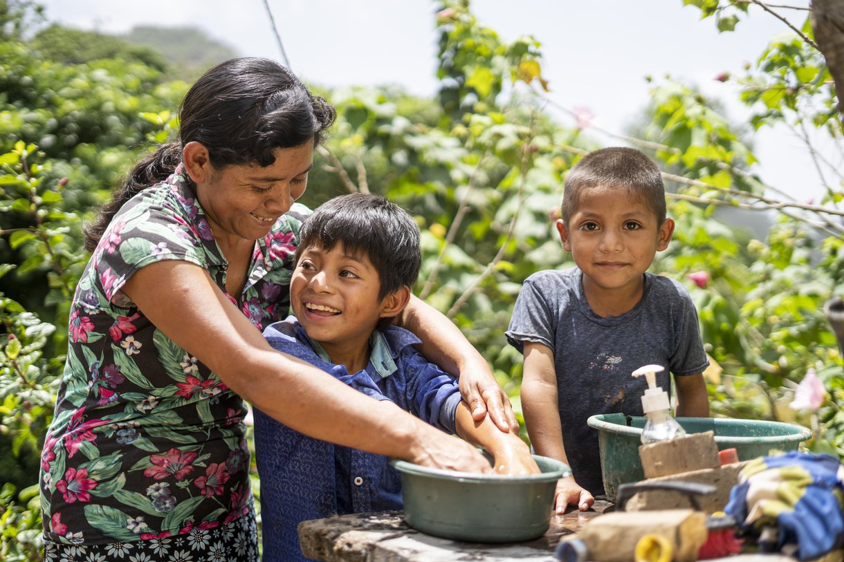 Juana Gutiérrez washes her son's hands at their home in Guatemala, in part of the country known as the Dry Corridor. Oxfam has been helping families here with soap to ensure they do not get water-borne diseases.