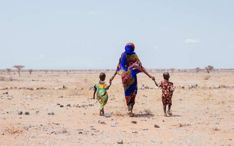Mother-and-two-small-children-walking-on-desserted-kenya