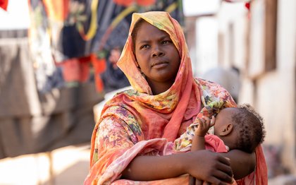 Woman holding infant child in south sudan