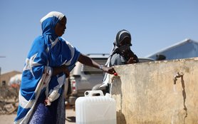 Amina Sahardid fills a jerry can with water from a newly installed tap served by a well rehabilitated by Oxfam near her home.