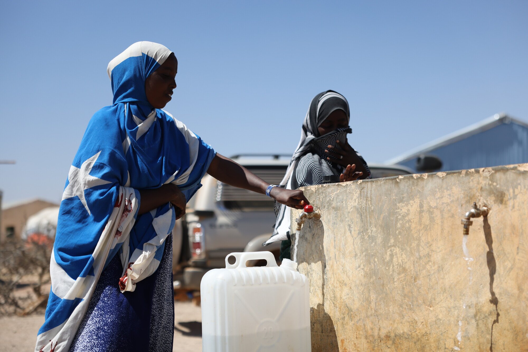 Amina Sahardid fills a jerry can with water from a newly installed tap served by a well rehabilitated by Oxfam near her home.