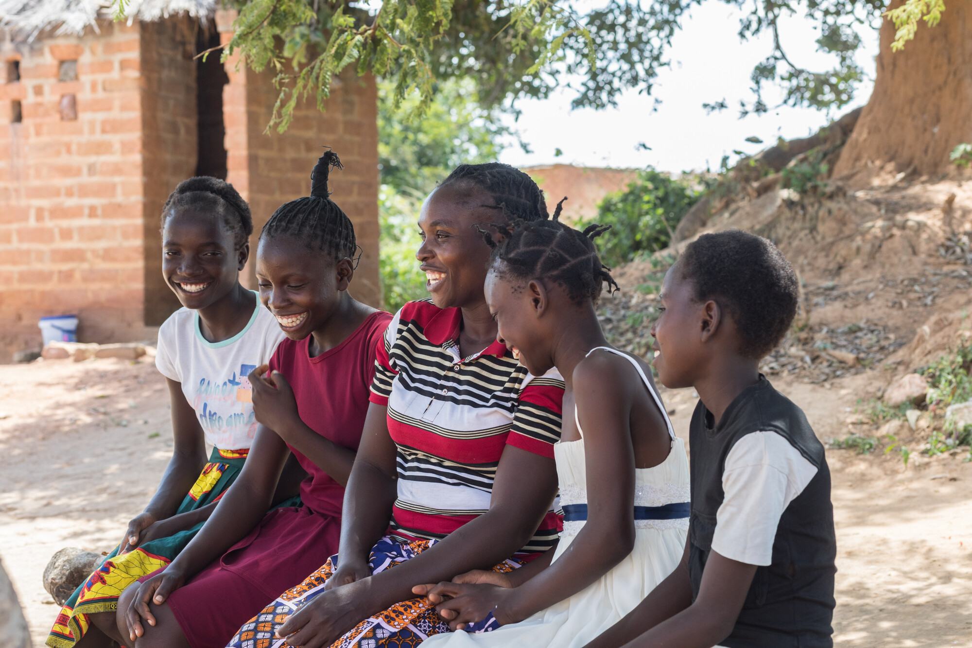  Angela Chiyala, a leader in a Farmer Field School in southern Zambia, laughs with four of her children outside their home. 