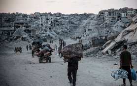 Palestinians displaced by conflict in Gaza walk across rubble-strewn streets to Jabalia, an area heavily damaged since the war began in October 2023.