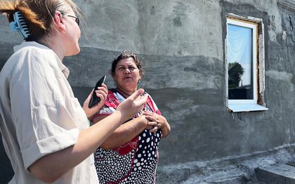 Oxfam program officer Iryna Kharlan-Plamenevska (left) inspects repairs on the home of Ratha Yurenko, which was damaged in fighting in Kharkiv.
