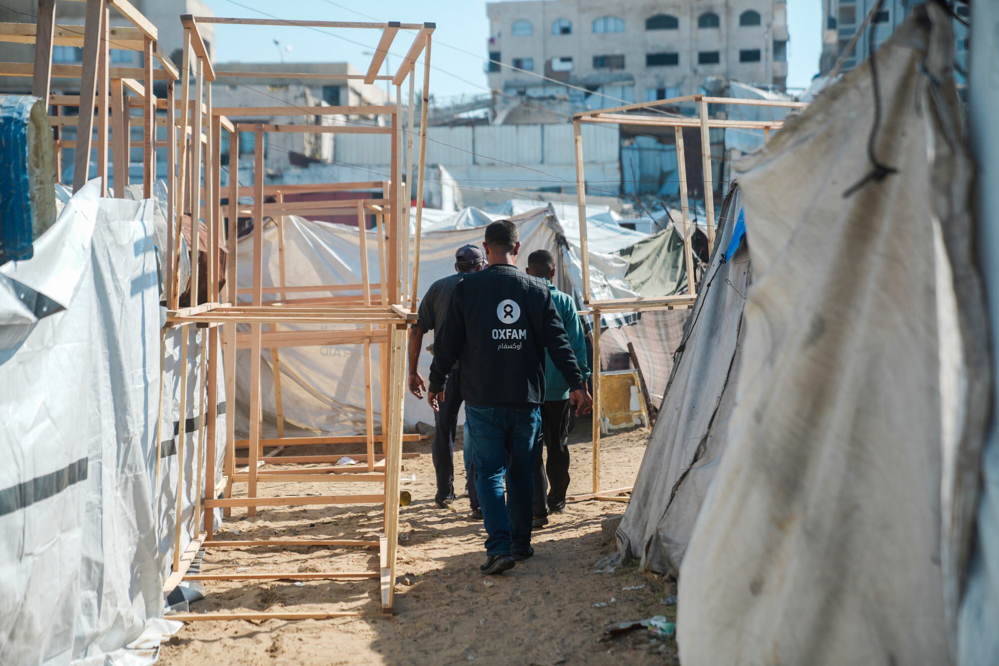  Oxfam staff check latrine construction at a make-shift tent site for displaced people in Gaza. 