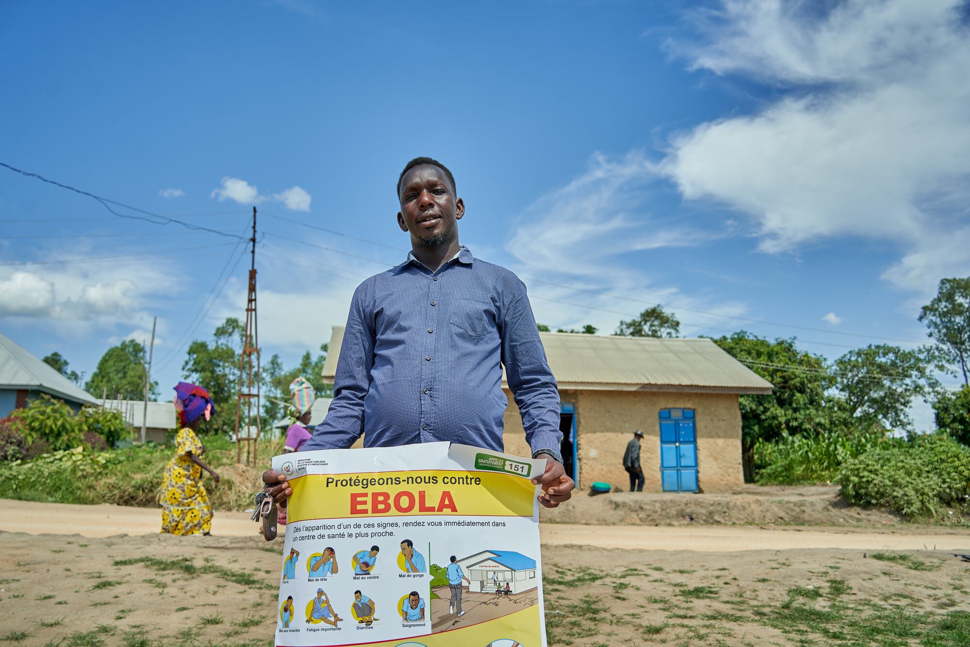  Salama Taga holds a poster with information about Ebola virus. He leads a youth organization in Rwampara, in Ituri province. He is helping to raise awareness of Ebola, and sharing information about prevention of the virus.  Azaria Muhongya / Oxfam 