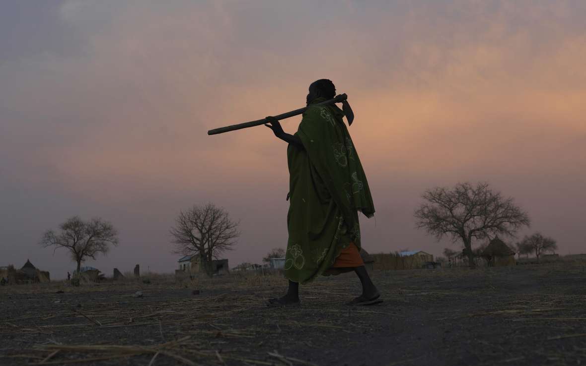  A woman farmer walks from her field to her home near Renk, in South Sudan. This area is hosting people who have crossed the border from Sudan to escape conflict. 