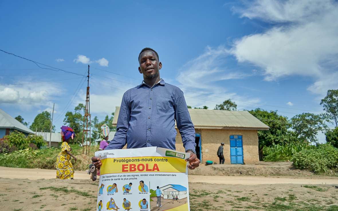  Salama Taga holds a poster with information about Ebola virus. He leads a youth organization in Rwampara, in Ituri province. He is helping to raise awareness of Ebola, and sharing information about prevention of the virus.  Azaria Muhongya / Oxfam 