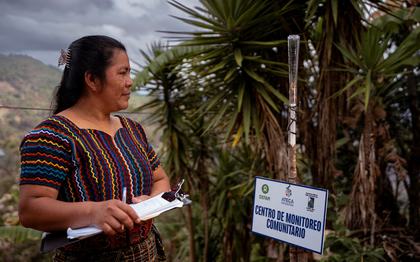 Doña Brenda Alicia Guanché Manuel, 35 years old, monitors the rain gauge outside her home in Chixim, Baja Verapaz, Guatemala. The daily weather observations she collects help small local farmers make informed decisions about planting in the Dry Corridor.