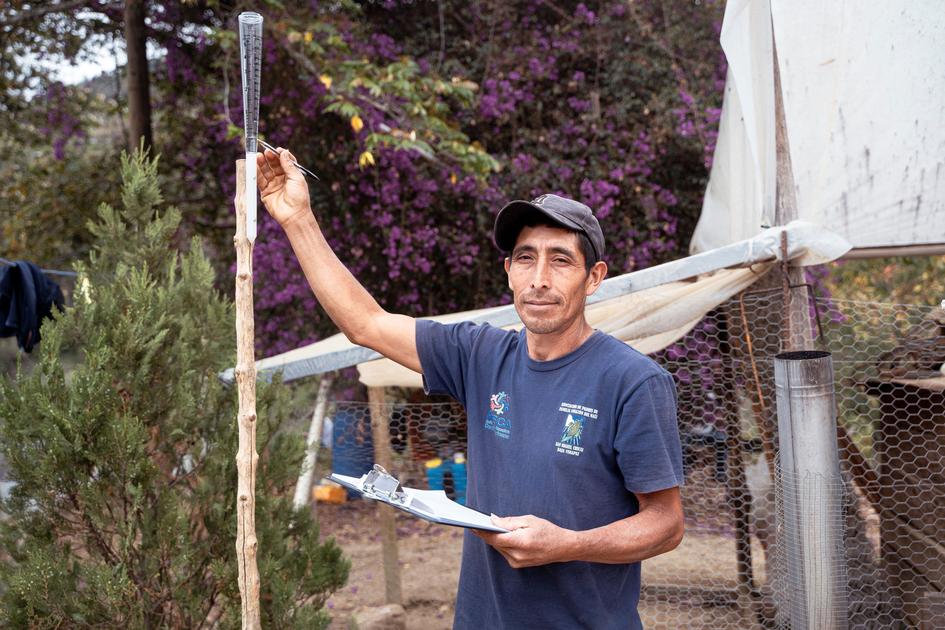  Don Mario René Gonzalez Córdova, 42 years old, monitors the rain gauge outside his home in Xesiguan, Baja Verapaz, Guatemala. The daily weather observations she collects help small local farmers make informed decisions about planting in the Dry Corridor. 