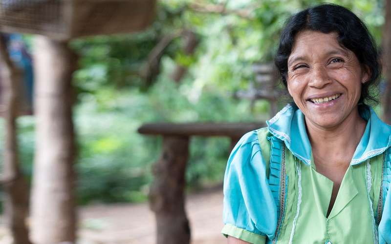 Woman in a blue and green shirt, smiling