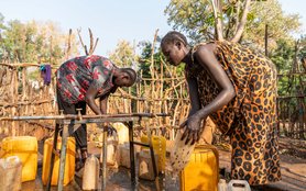 Two women fill water jugs in the Gambella refugee camp in Ethiopia.